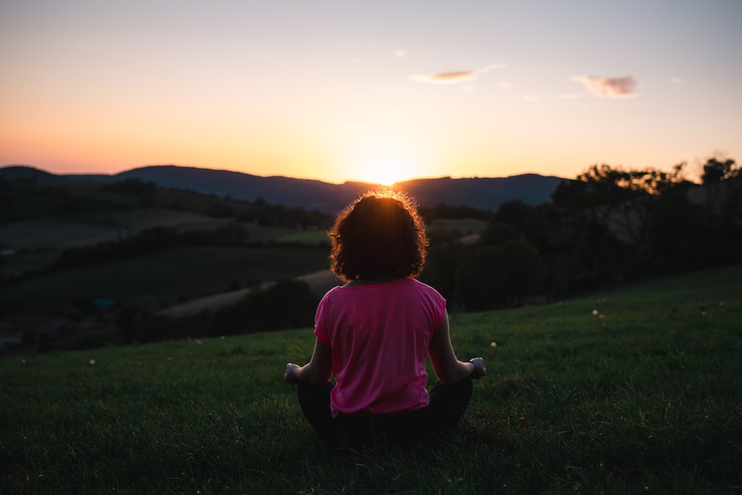 Person sitting in a meditative yoga pose in a calm, light-filled space